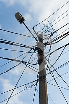 Lamp pole and cross of tangled electric wires photo