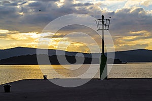 Lamp post on a dock against a cloudy sky at dusk