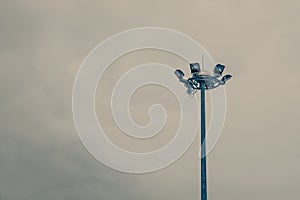 Lamp post electricity industry with blue sky background. Spotlight tower, vintage tone.