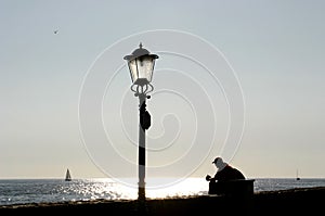 Lamp post and resting man