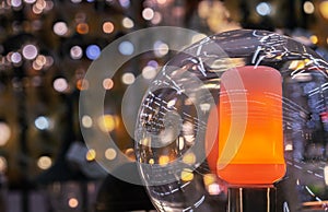 Lamp with a round plafond and an orange candle on a bokeh background