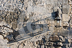 Lamp on a rustic wall with shadow