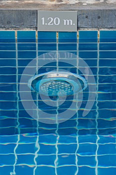 Lamp in swimming pool with warning sign showing the depth of the swimming pool.
