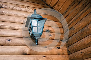 Lamp on the wall of an old wooden log house