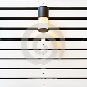 Lamp on white lath wall