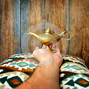 Lamp of wishes in a hand. Aladin lamp photo