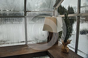 Lamp of Wood Shelf with Condensation on Windows.