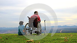 2023-05-01:Lampang Thailand:A disabled man sits in a wheelchair-accessible vehicle, while an elderly woman sits beside him on the