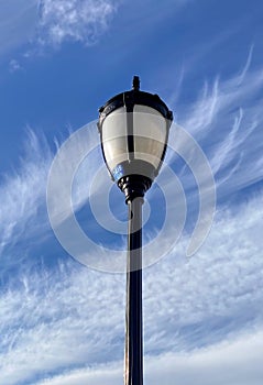 Lamppost against the sky with wispy clouds