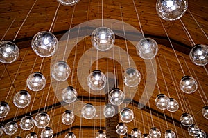 Lamps hanging on celling. Wood background. Warm light. Modern design. View from below.