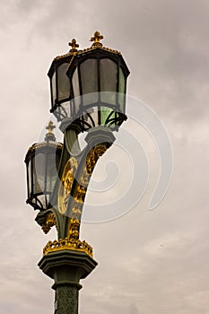 Lamps lining the Westminster Bridge stand out against a grey winter sky.