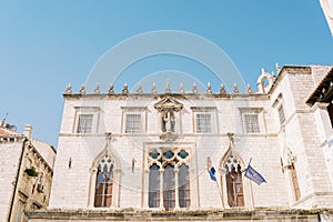 Lancet windows and sculpture on the facade of the ancient Sponza Palace. Dubrovnik, Croatia