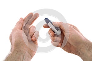 The lancing device is directed to the tip of the finger for analysis for diabetes. Isolated on a white background