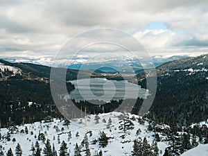 Land covered with snow overlooking the Donner Lake in Truckee, California under cloudy skies