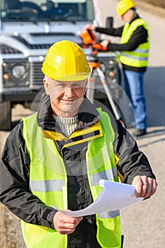 Land geodesist man hold plan reflective vest