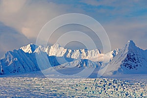 Land of ice. Travelling in Arctic Norway. White snowy mountain, blue glacier Svalbard, Norway. Ice in ocean. Iceberg in North pole