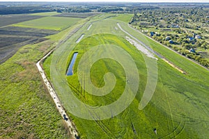 Land improvement or land amelioration concept, drone flying over narrow irrigation or drainage channels on rye or wheat field.