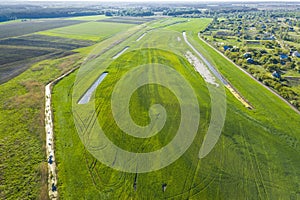 Land improvement or land amelioration concept, drone flying over narrow irrigation or drainage channels on rye or wheat field.