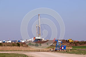 Land oil and gas drilling rig and pump jack in oilfield