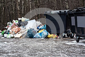 Land pollution and plastic waste. Trash heaps on the street and ecological problems. Big pile of garbage near garbage bins