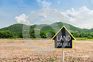 Land for sale sign against trimmed lawn background