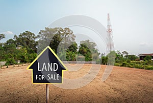 Land for sale sign against trimmed lawn background. Empty dry cracked swamp reclamation soil