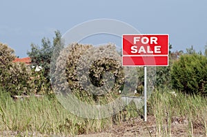 Land for sale sign in empty field