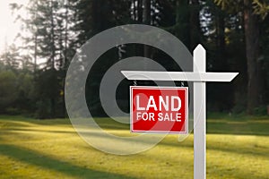 LAND FOR SALE SIGN on empty meadow - Real estate conceptual image.