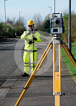 Land surveyor performing initial survey of the road levels and kerb lines before start of construction works using robotic