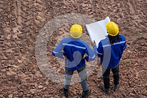 Land surveyor team standing working together at construction field consult study looking building location with floor plan