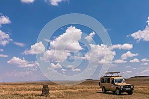 Landcruiser Toyota van vehicle parked against stone block showing the border of the Serengeti and Maasai Mara Triangle National Ga