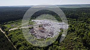 Landfill removal of unsorted debris in the middle of the forest. Aerial photography with drone