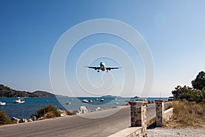 Landing of an airliner on the airport runway in the summer, passing over the marina