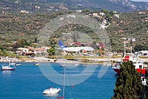 Landing of an airliner on the airport runway in the summer, passing over the marina