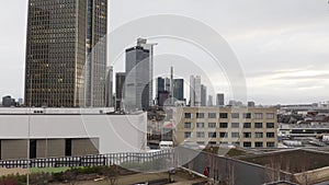 Landing footage on green roof of sustainable building. View of group of tall office high rise buildings in city