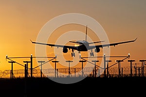 Landing passenger plane during sunset