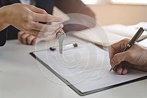 Landlord giving a house keys to tenant after signed rental contract photo