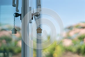 Landlord key for unlocking house is plugged into the door. Second hand house for rent and sale. keychain is blowing in the wind.