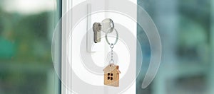 Landlord key for unlocking house is plugged into the door. Second hand house for rent and sale. keychain is blowing in the wind.