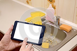 The landlord uses the tablet to call a cleaner in order to clean the clogged kitchen sink