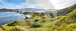 Landmark panoramic view of `Gili Lawa` with green savanna grass and blue sea in an evening, Komodo Island, Labuan Baj