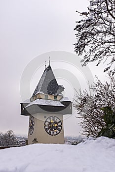 Landmark Uhrturm on hill Schlossberg in Graz on snowy winterday