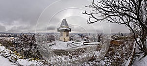 Landmark Uhrturm on hill Schlossberg in Graz on snowy winterday