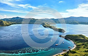 Landmark view of `Gili Lawa` with green savanna grass and blue sea in an evening, Komodo Island Komodo National Park, Labuan Baj