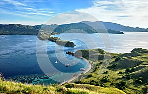 Landmark view of `Gili Lawa` with green savanna grass and blue sea in an evening, Komodo Island Komodo National Park, Labuan Baj