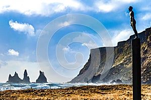 Landscae with Seafarer statue on the black sand beach of Vik, Ic