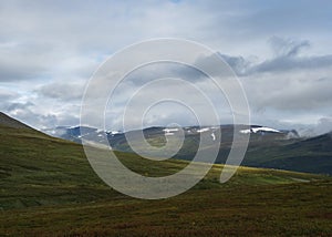 Landscap of Lapland nature at Kungsleden hiking trail with colorful mountains, rocks, autumn colored bushes, birch tree and heath