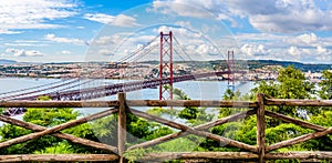 Landscape of the 25th of April bridge over the Tagus river estuary into Lisbon skyline as seen from the hills of Almada with