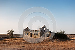 Landscape of abandoned house in dry field.