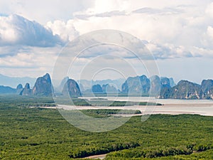 Landscape abundant nature tropical mangrove forest intertidal forest around limestone karst mountain sea blue sky white cloud.